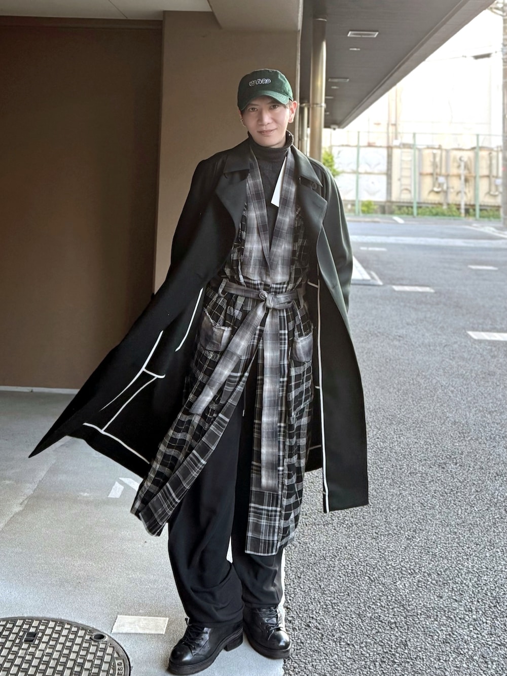 グリーン系のトレンチコート、ブラック系のモッズコート、ブラック系のショルダーバッグを着用したメンズの冬コーディネートの3枚目の写真