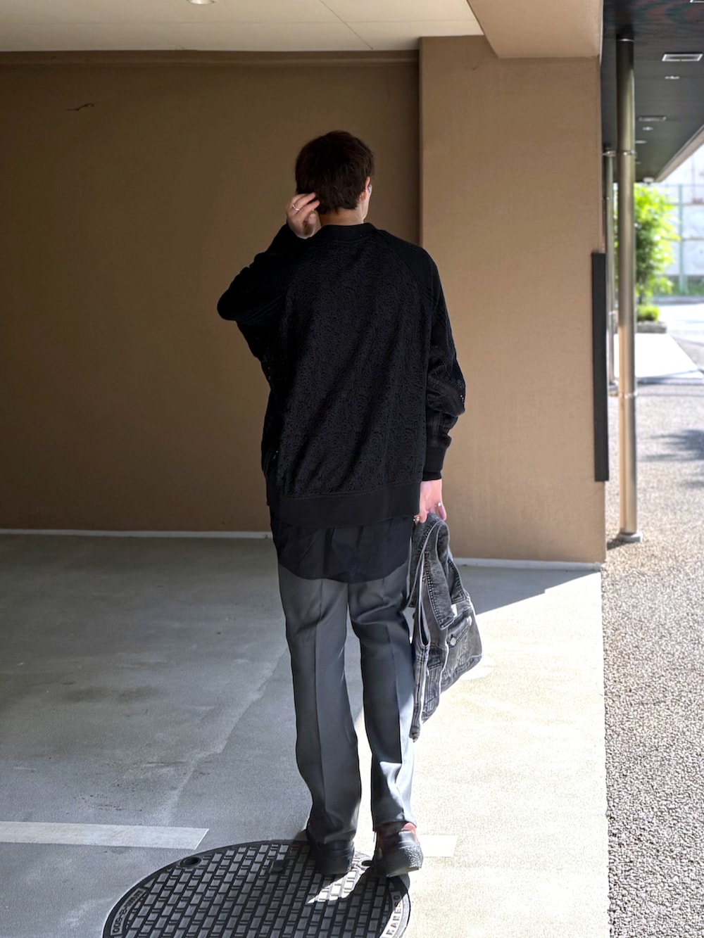 ブラック系のブルゾン、ブラック系のTシャツ/カットソー、ブラック系のトートバッグを着用したメンズの春コーディネートの3枚目の写真