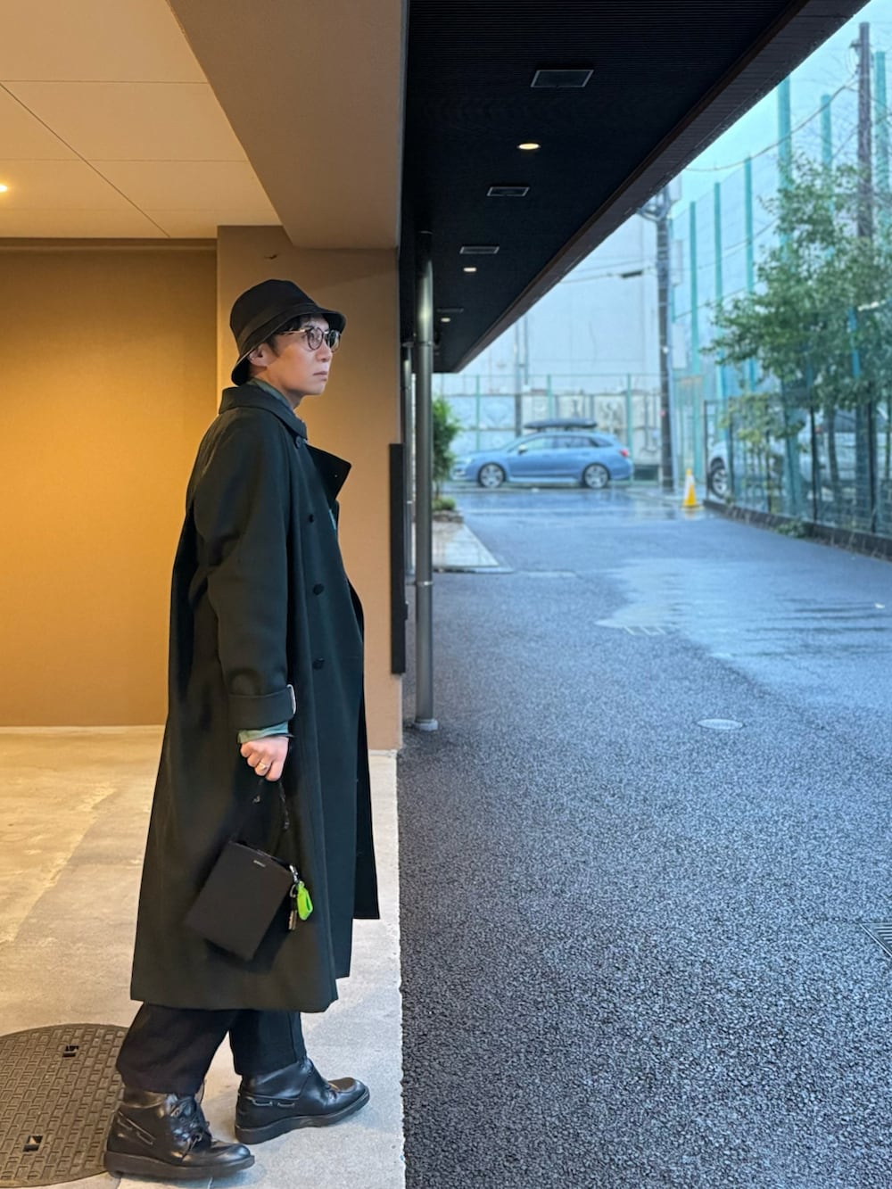 グリーン系のシャツ/ブラウス、グリーン系のニット/セーター、グリーン系のトレンチコートを着用したメンズの春コーディネートの2枚目の写真