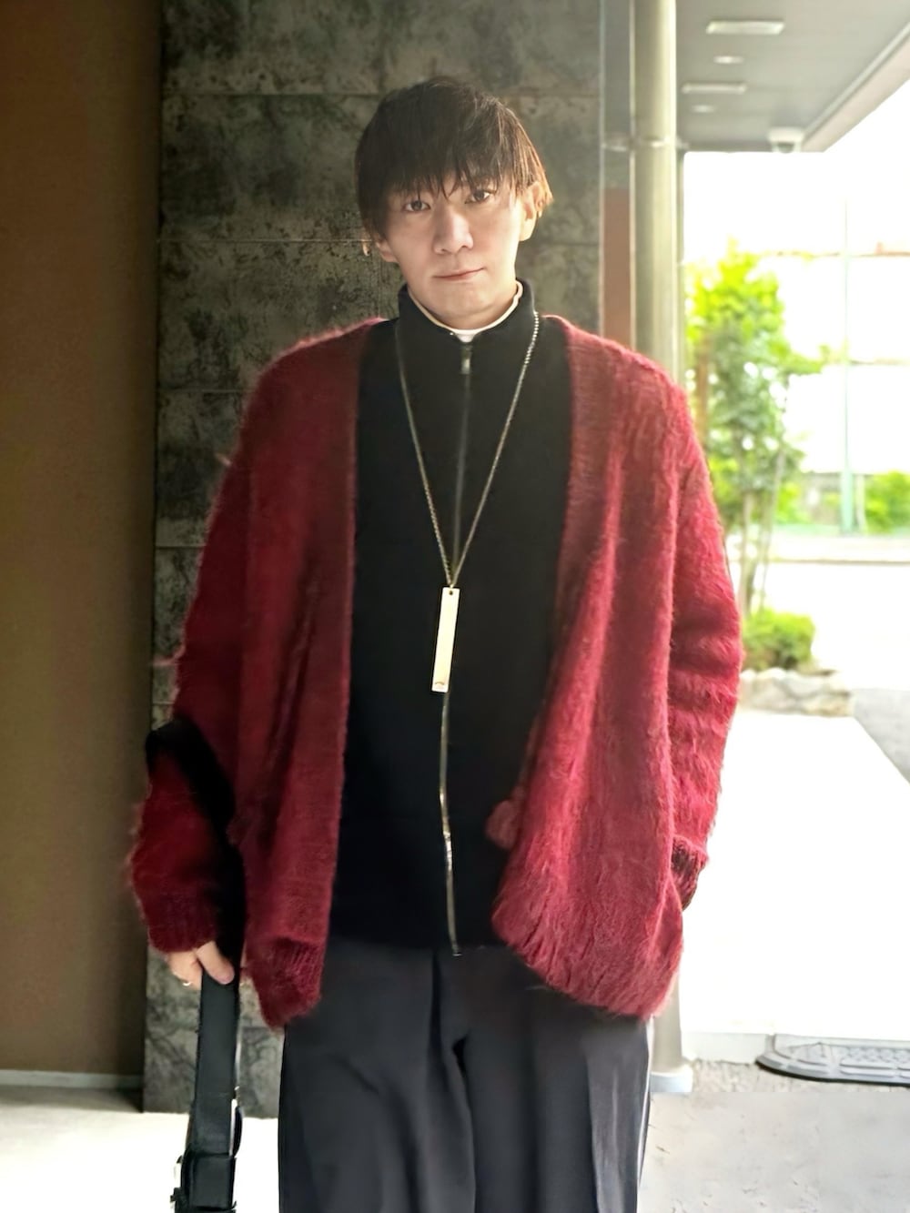 ブラック系のニット/セーター、レッド系のカーディガン/ボレロ、グレー系のその他パンツを着用したメンズの冬コーディネートの3枚目の写真