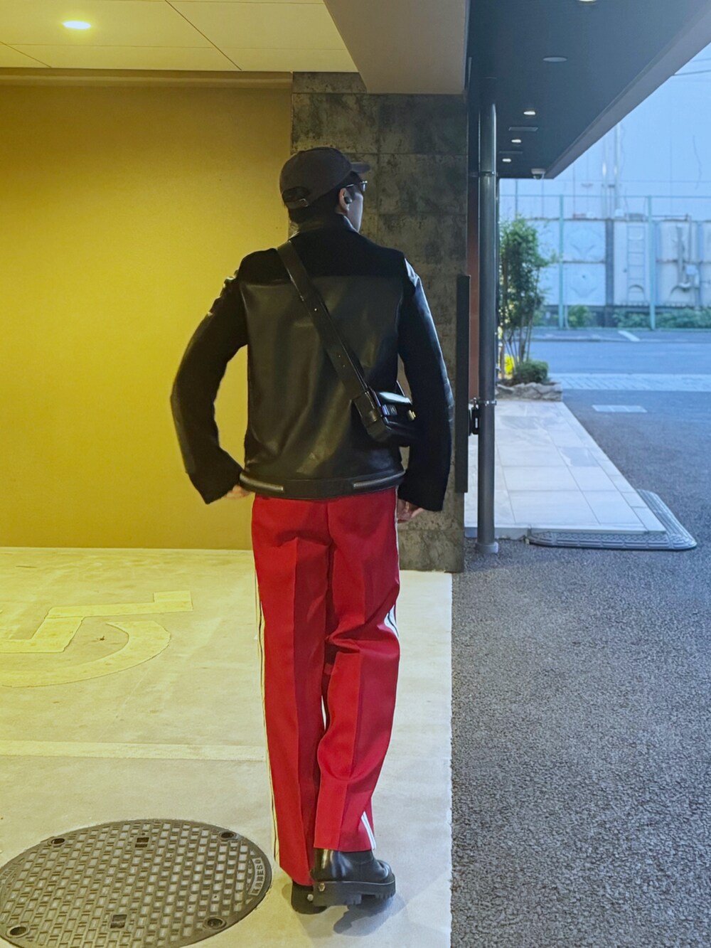 ブラック系のライダースジャケット、ブラック系のニット/セーター、ブラック系のショルダーバッグを着用したメンズの冬コーディネートの2枚目の写真
