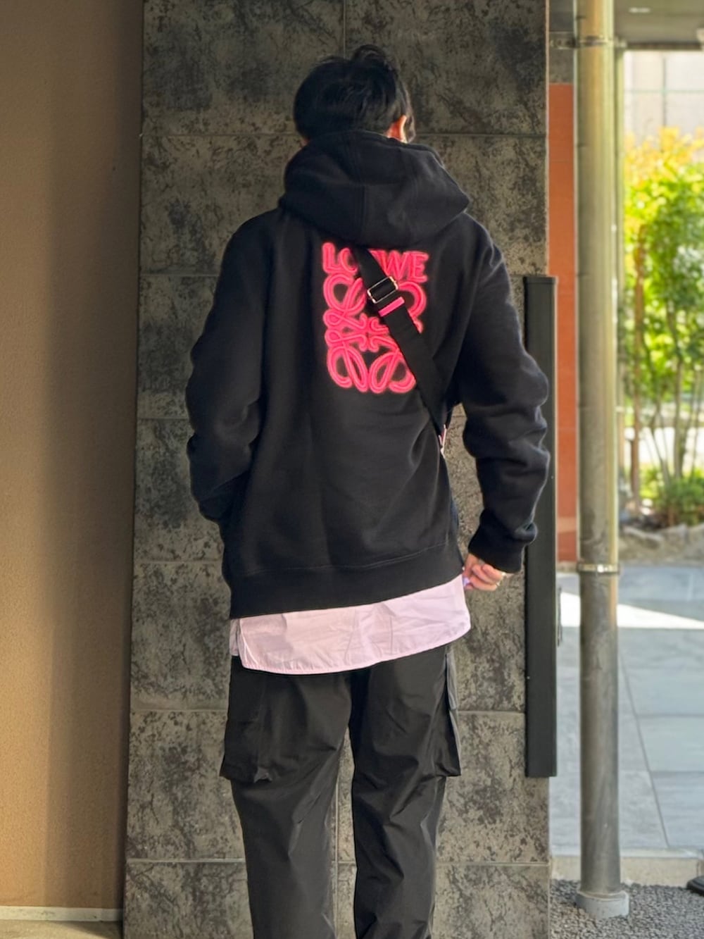 ピンク系のシャツ/ブラウス、ブラック系のパーカー、ピンク系のショルダーバッグを着用したメンズの冬コーディネートの2枚目の写真