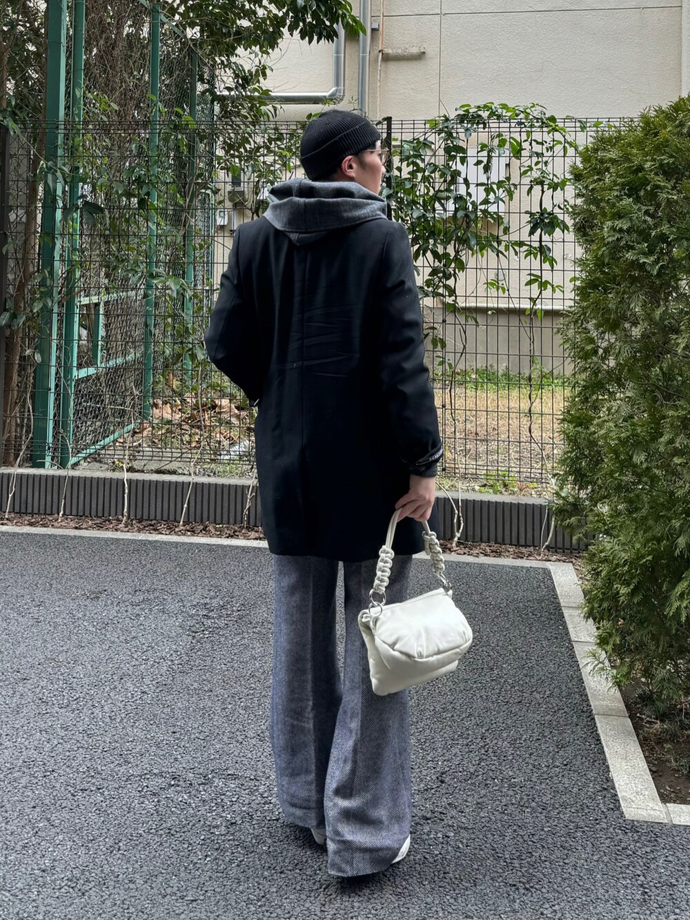 グレー系のパーカー、ホワイト系のショルダーバッグ、その他のスラックスを着用したメンズの春コーディネートの2枚目の写真