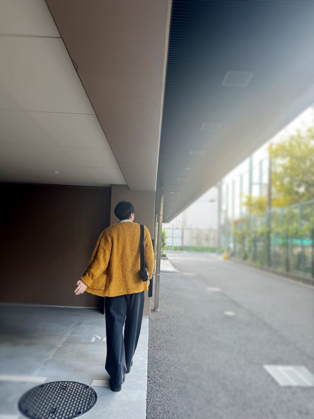 イエロー系のカーディガン/ボレロ、グレー系のシャツ/ブラウス、ブラック系のショルダーバッグを着用したメンズの冬コーディネートの2枚目の写真