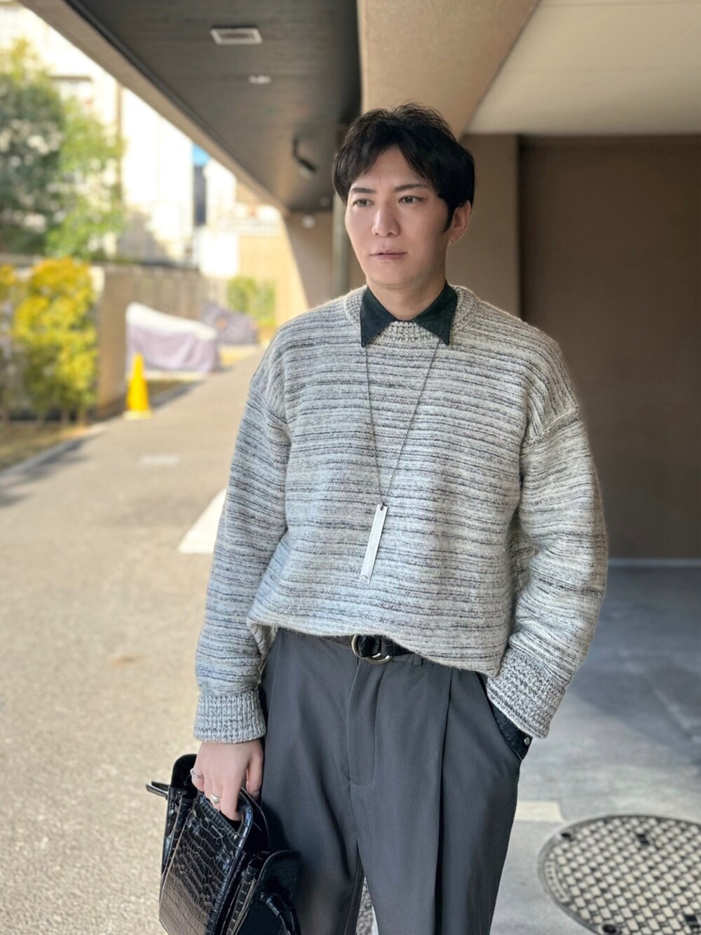 ブラック系のシャツ/ブラウス、ブラック系のハンドバッグ、グレー系のスラックスを着用したメンズの冬コーディネートの3枚目の写真