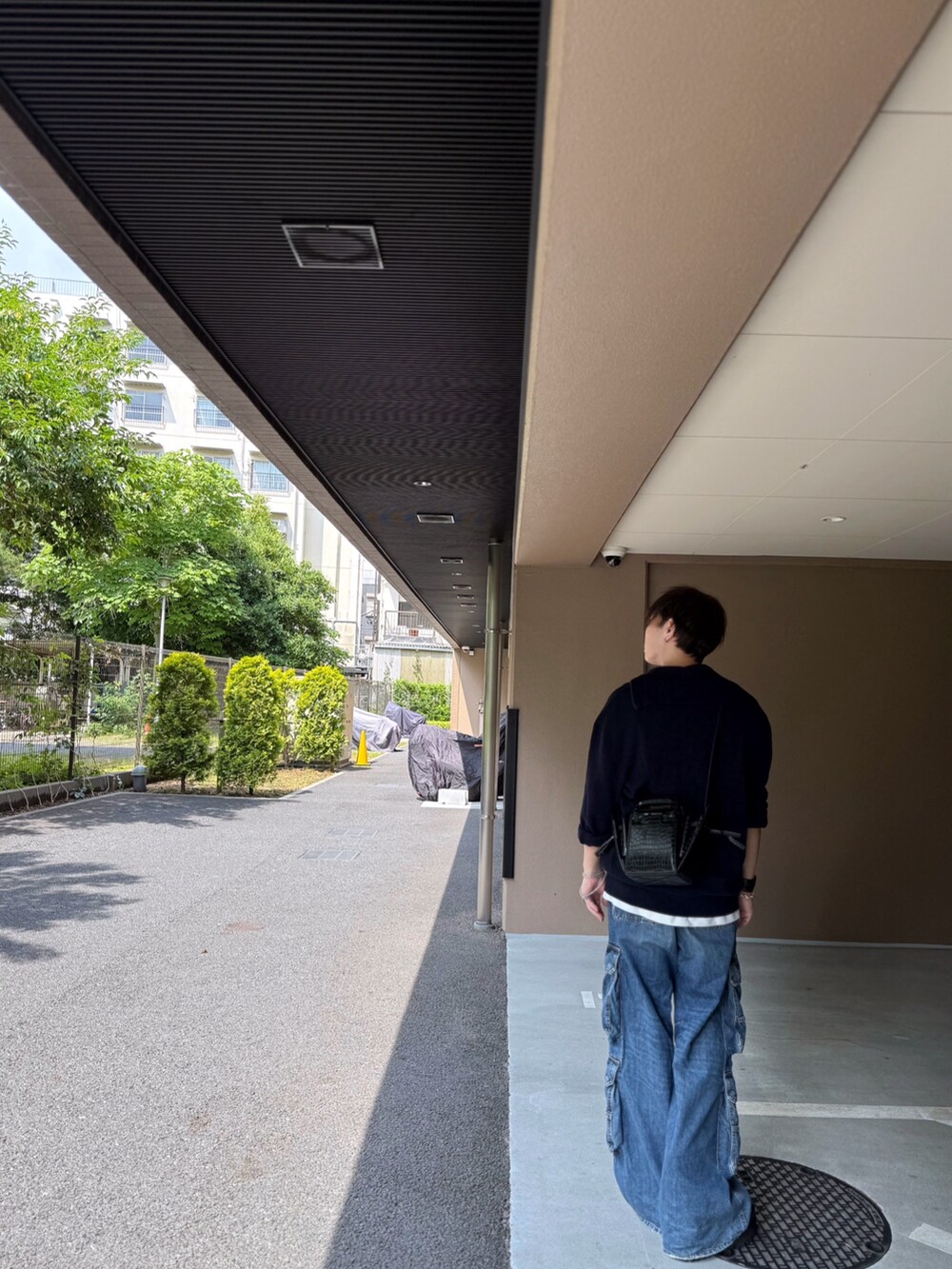 ホワイト系のタンクトップ、パープル系のトップス、ブルー系のデニムパンツを着用したメンズの夏コーディネートの2枚目の写真