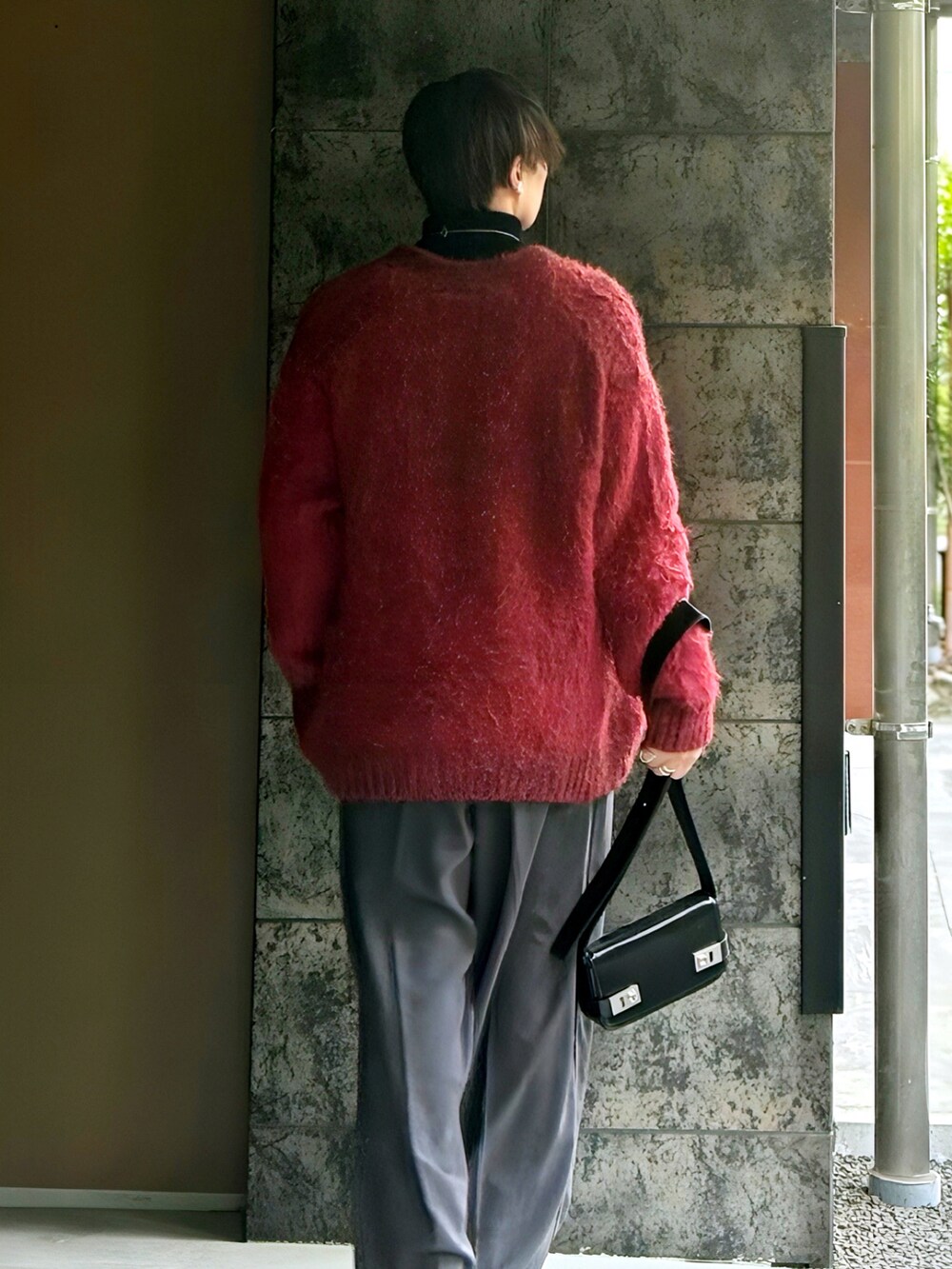 ブラック系のニット/セーター、レッド系のカーディガン/ボレロ、グレー系のその他パンツを着用したメンズの冬コーディネートの2枚目の写真