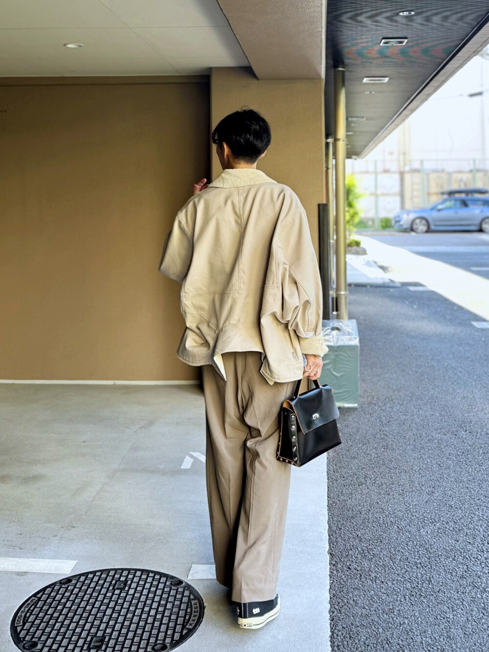 ベージュ系のブルゾン、ホワイト系のニット/セーター、ベージュ系のスラックスを着用したメンズの冬コーディネートの3枚目の写真