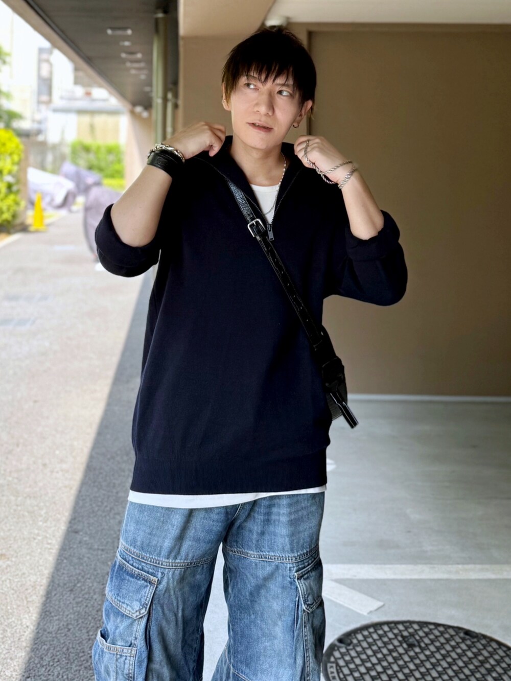 ホワイト系のタンクトップ、パープル系のトップス、ブルー系のデニムパンツを着用したメンズの夏コーディネートの3枚目の写真