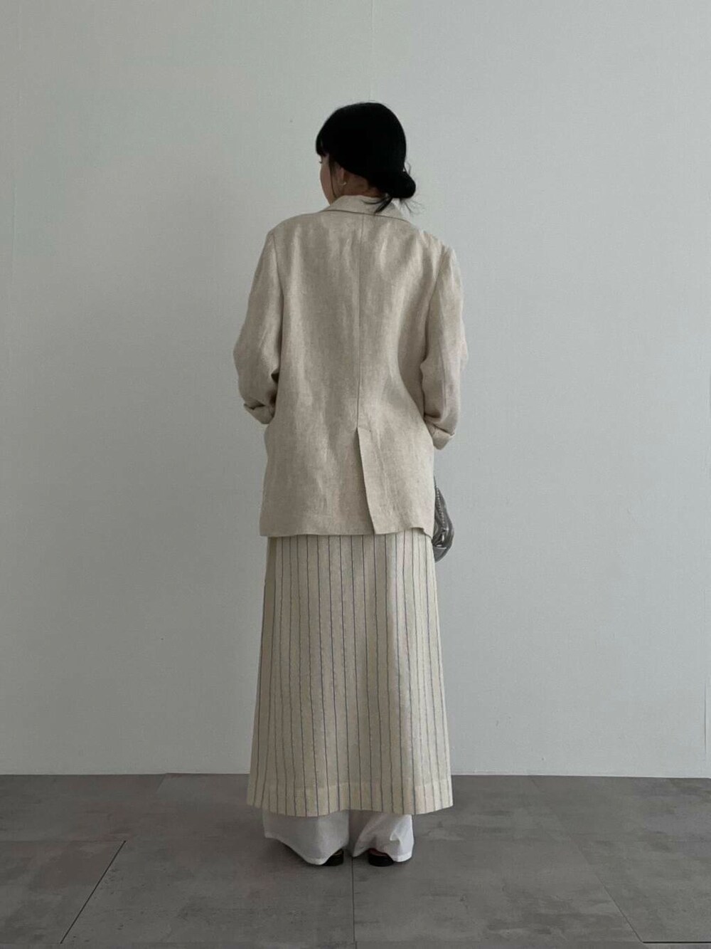 シルバー系のショルダーバッグ、ブラック系のパンプス、ベージュ系のその他アウターを着用したレディースの春コーディネートの3枚目の写真