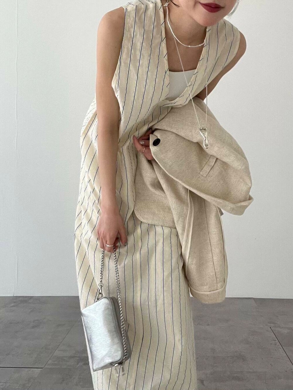 シルバー系のショルダーバッグ、ブラック系のパンプス、ベージュ系のその他アウターを着用したレディースの春コーディネートの5枚目の写真