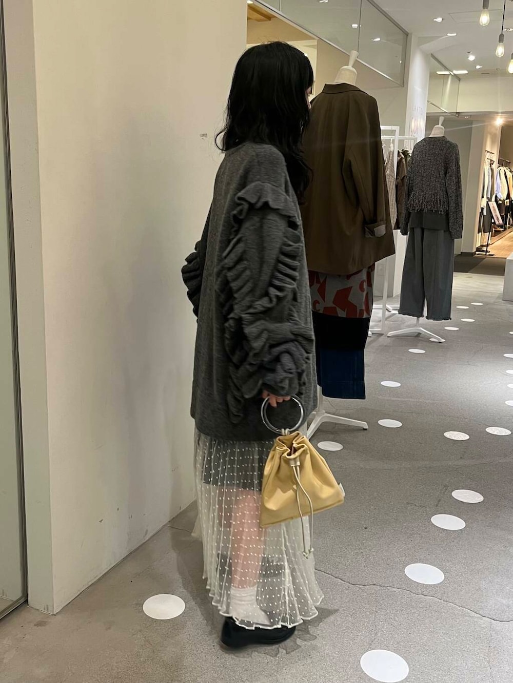 ホワイト系のスカート、グレー系のその他パンツ、イエロー系のショルダーバッグを着用したレディースの秋コーディネートの4枚目の写真