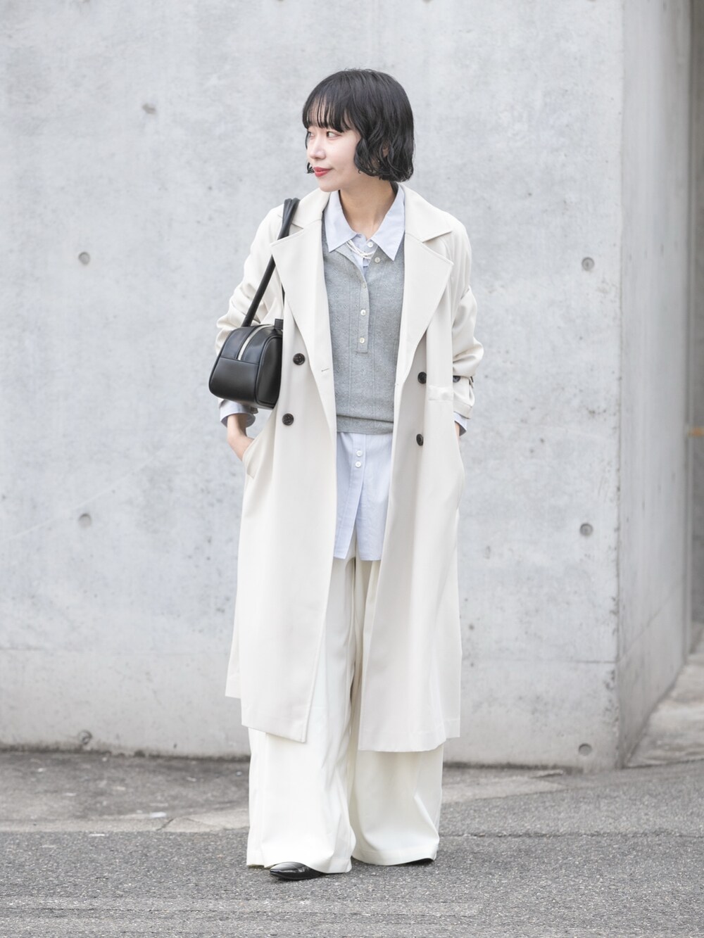 グレー系のトレンチコート、グレー系のニット/セーター、ブルー系のシャツ/ブラウスを着用したレディースの冬コーディネートの5枚目の写真