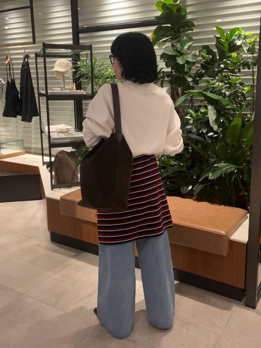 ホワイト系のニット/セーター、グレー系のTシャツ/カットソー、ブルー系のデニムパンツを着用したレディースの秋コーディネートの4枚目の写真