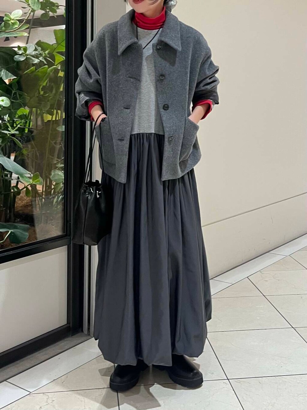 ブラック系のショルダーバッグ、レッド系のTシャツ/カットソー、ブラック系のブーツを着用したレディースの秋コーディネートの4枚目の写真