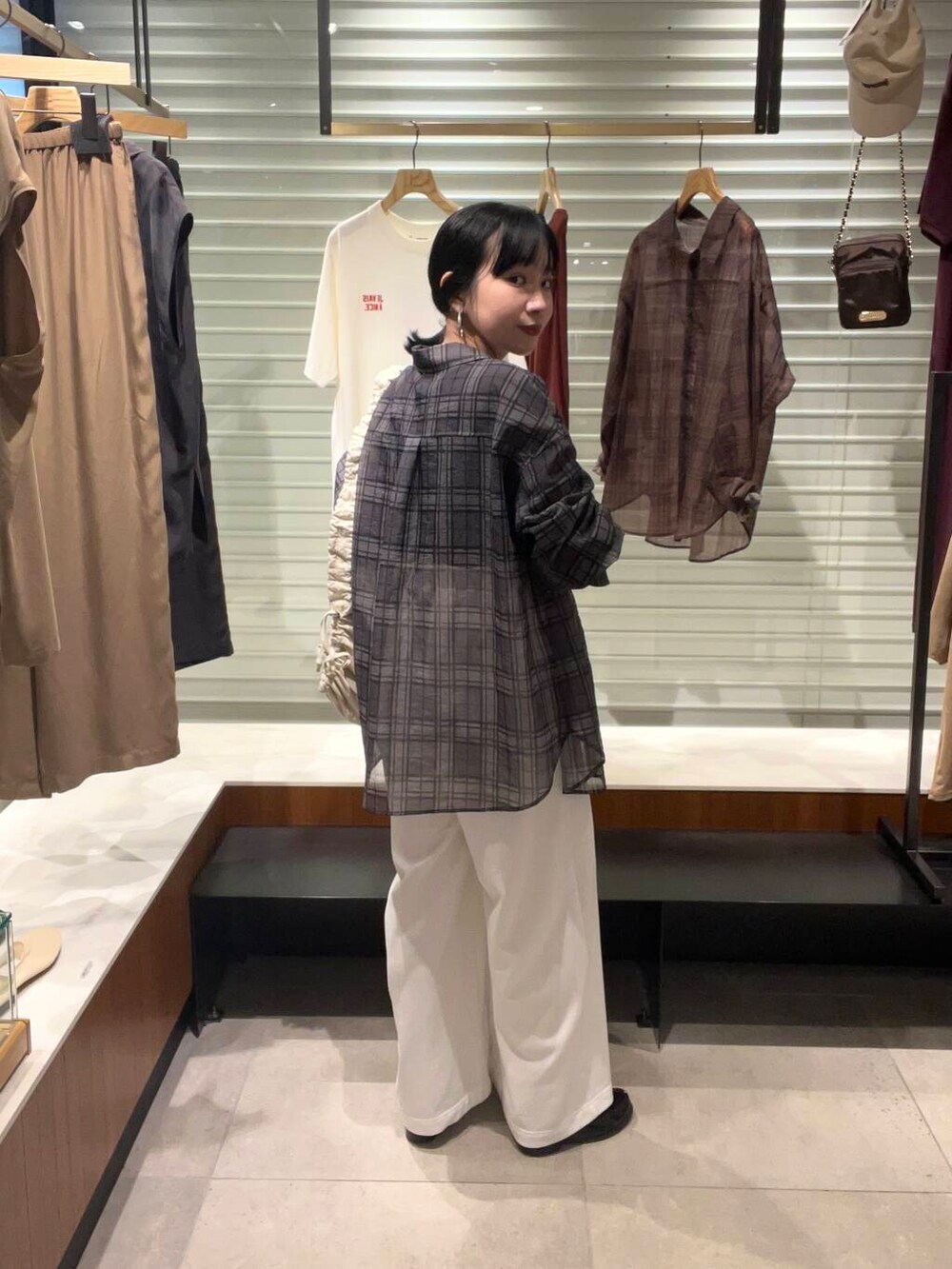 ホワイト系のその他パンツ、グレー系のシャツ/ブラウス、ホワイト系のショルダーバッグを着用したレディースの夏コーディネートの3枚目の写真