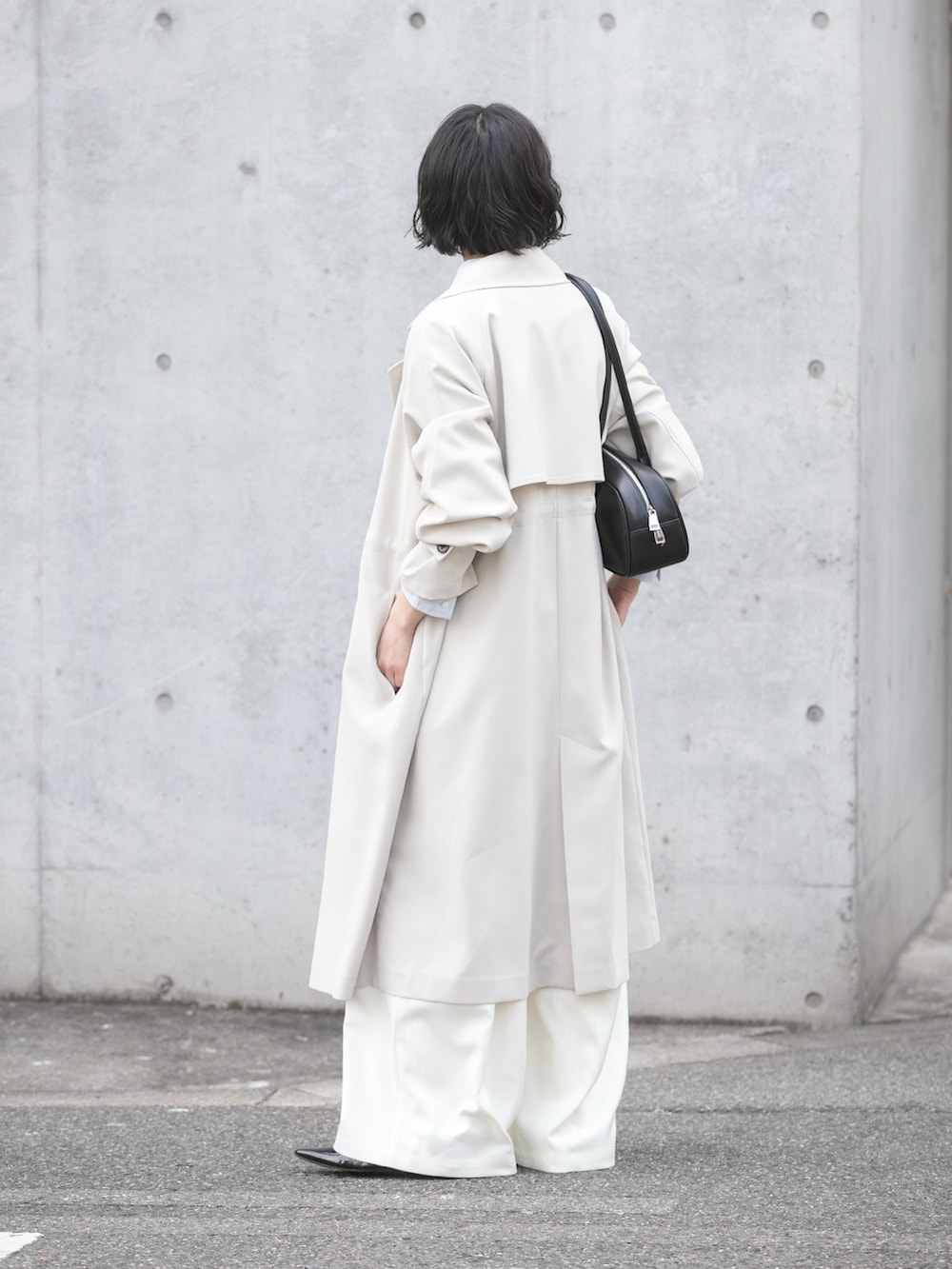 グレー系のトレンチコート、グレー系のニット/セーター、ブルー系のシャツ/ブラウスを着用したレディースの冬コーディネートの4枚目の写真