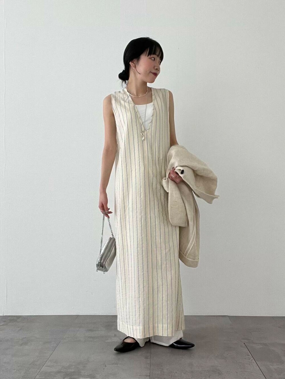 シルバー系のショルダーバッグ、ブラック系のパンプス、ベージュ系のその他アウターを着用したレディースの春コーディネートの4枚目の写真