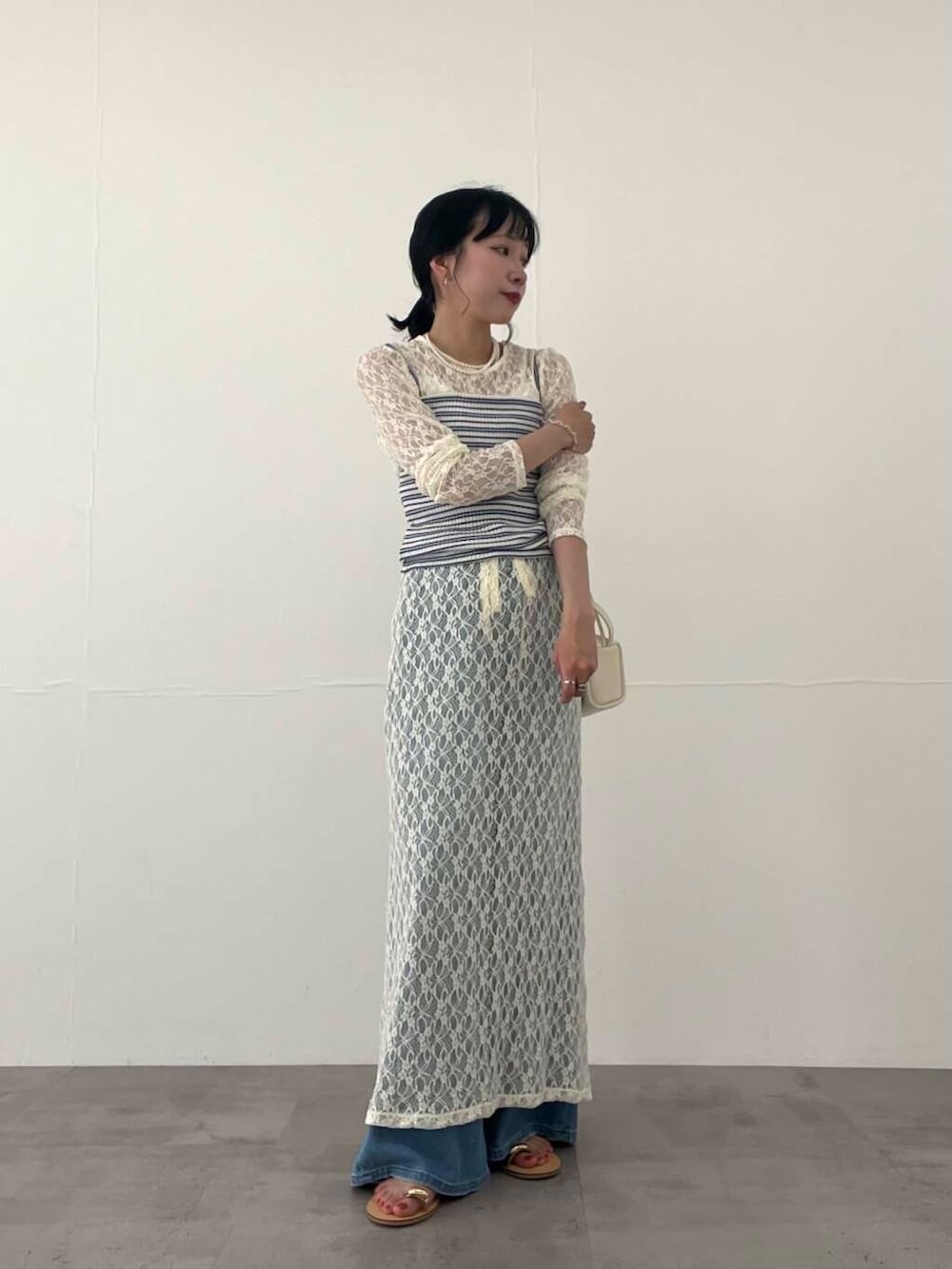 その他のキャミソール、ブルー系のデニムパンツ、ホワイト系のショルダーバッグを着用したレディースの夏コーディネートの7枚目の写真