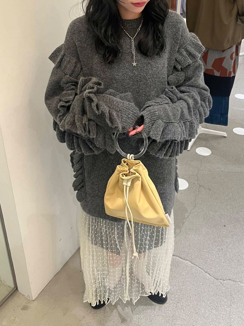 ホワイト系のスカート、グレー系のその他パンツ、イエロー系のショルダーバッグを着用したレディースの秋コーディネートの6枚目の写真