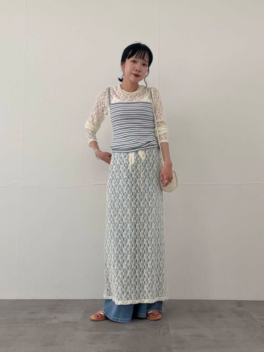 その他のキャミソール、ブルー系のデニムパンツ、ホワイト系のショルダーバッグを着用したレディースの夏コーディネートの6枚目の写真