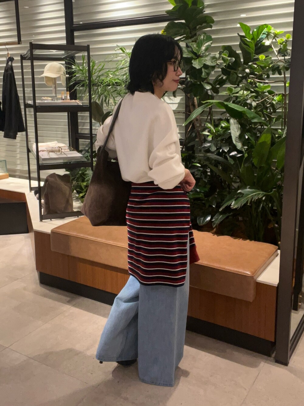 ホワイト系のニット/セーター、グレー系のTシャツ/カットソー、ブルー系のデニムパンツを着用したレディースの秋コーディネートの3枚目の写真