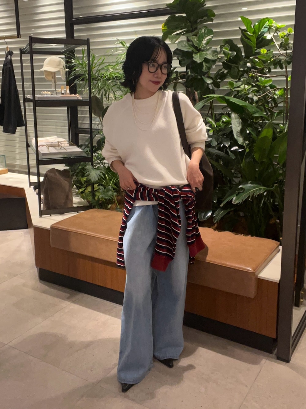 ホワイト系のニット/セーター、グレー系のTシャツ/カットソー、ブルー系のデニムパンツを着用したレディースの秋コーディネートの2枚目の写真