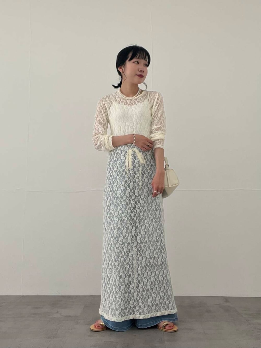 その他のキャミソール、ブルー系のデニムパンツ、ホワイト系のショルダーバッグを着用したレディースの夏コーディネートの2枚目の写真