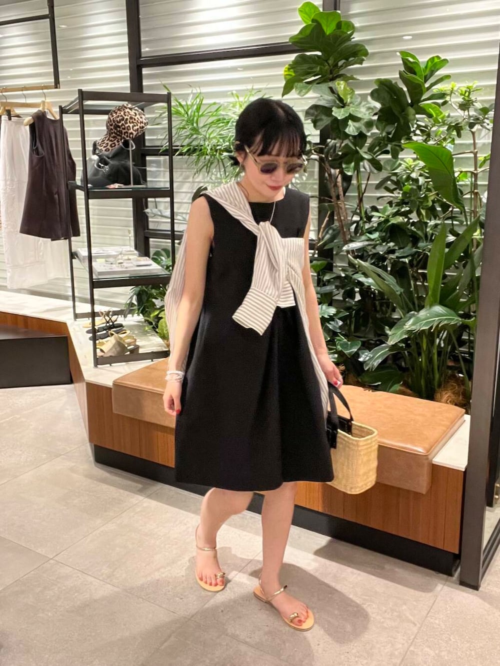 ブラック系のかごバッグ、ブラック系のシャツ/ブラウス、ゴールド系のサンダルを着用したレディースの夏コーディネートの3枚目の写真