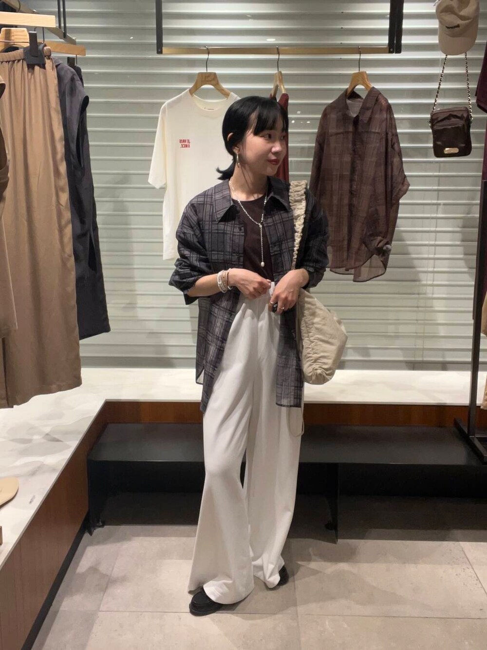 ホワイト系のその他パンツ、グレー系のシャツ/ブラウス、ホワイト系のショルダーバッグを着用したレディースの夏コーディネートの2枚目の写真