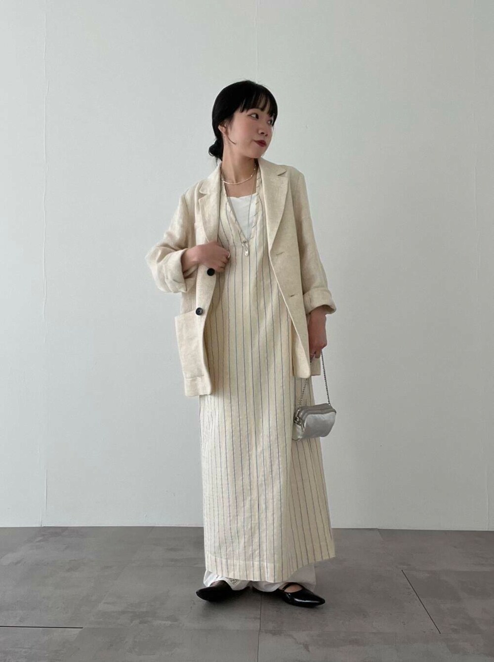 シルバー系のショルダーバッグ、ブラック系のパンプス、ベージュ系のその他アウターを着用したレディースの春コーディネートの2枚目の写真