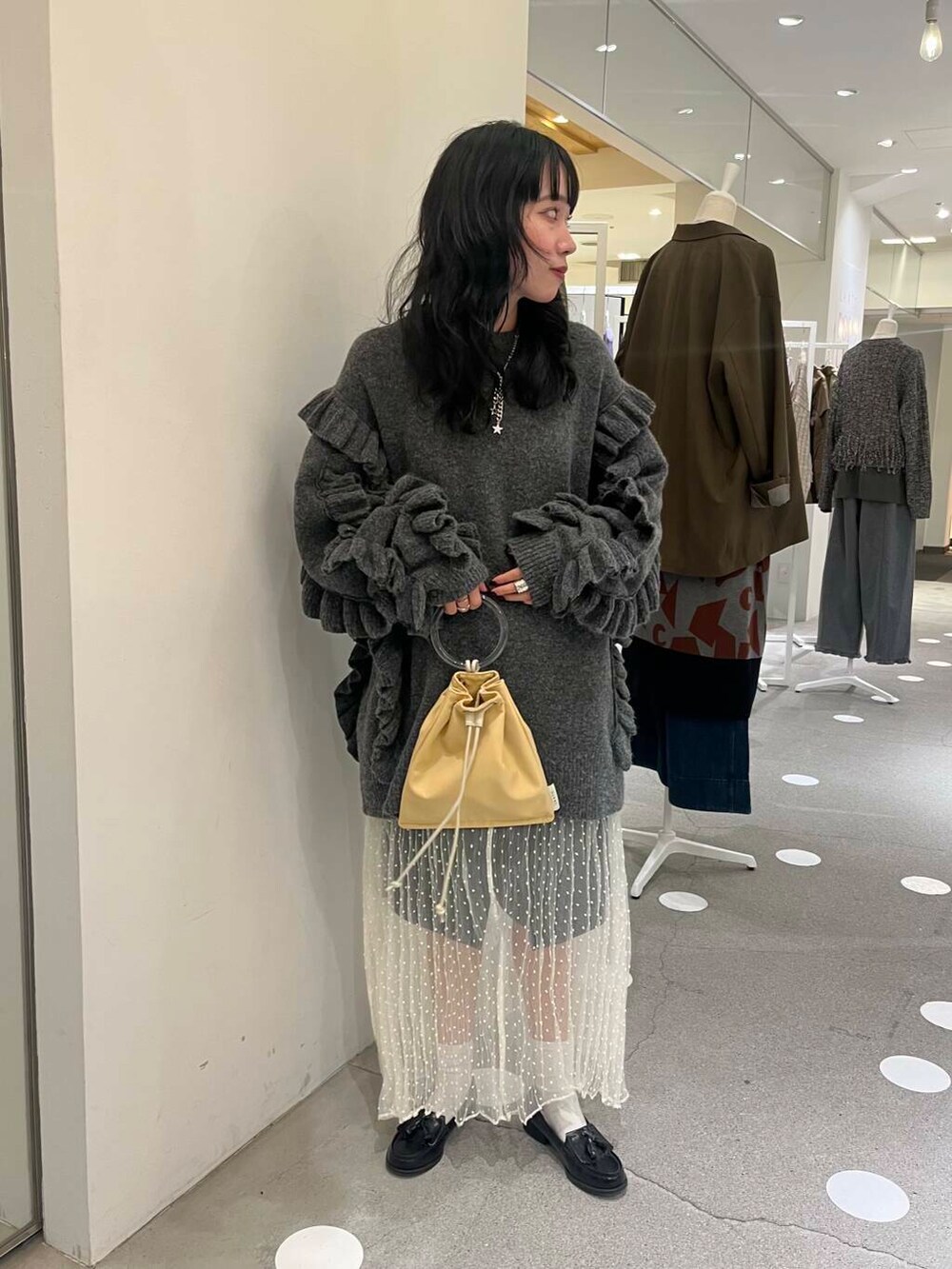 ホワイト系のスカート、グレー系のその他パンツ、イエロー系のショルダーバッグを着用したレディースの秋コーディネートの2枚目の写真