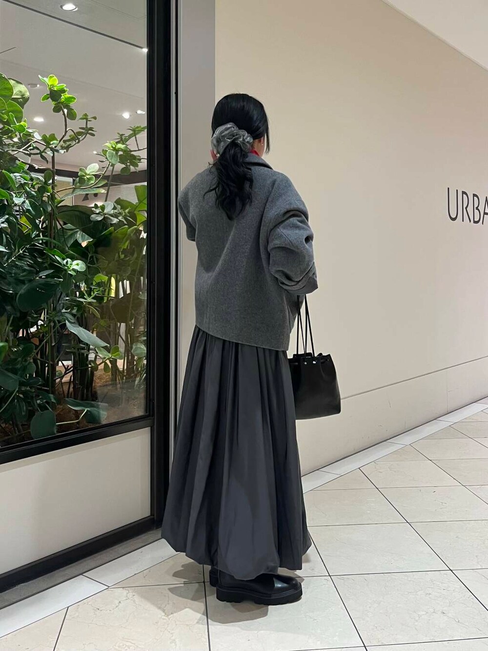 ブラック系のショルダーバッグ、レッド系のTシャツ/カットソー、ブラック系のブーツを着用したレディースの秋コーディネートの3枚目の写真