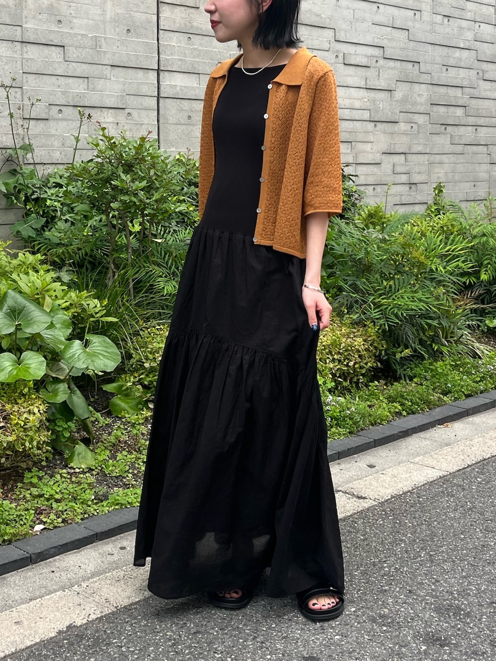 ブラウン系のニット/セーター、ブラック系のかごバッグ、ブラック系のサンダルを着用したレディースの春コーディネートの4枚目の写真