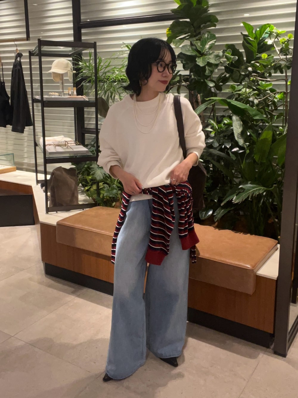 ホワイト系のニット/セーター、グレー系のTシャツ/カットソー、ブルー系のデニムパンツを着用したレディースの秋コーディネートの5枚目の写真