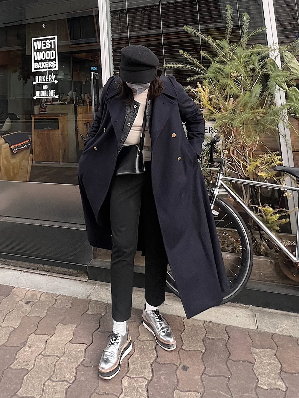 ブラック系のスラックス、シルバー系のローファー、ブルー系のその他アウターを着用したレディースの冬コーディネートの2枚目の写真