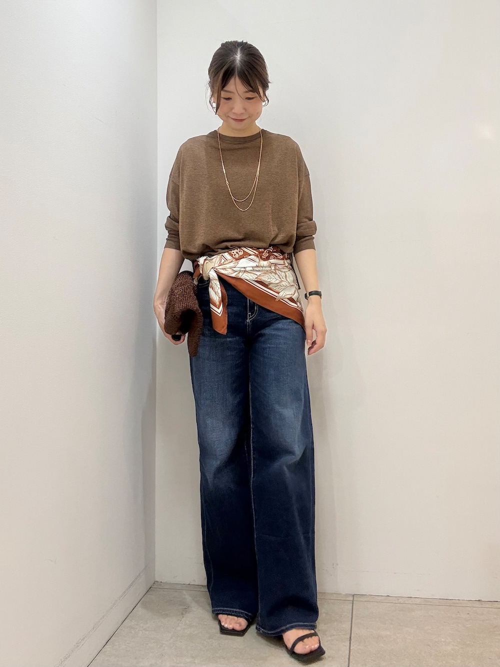 ブラウン系のカーディガン/ボレロ、ブラック系のタンクトップ、ブルー系のデニムパンツを着用したレディースの夏コーディネートの2枚目の写真