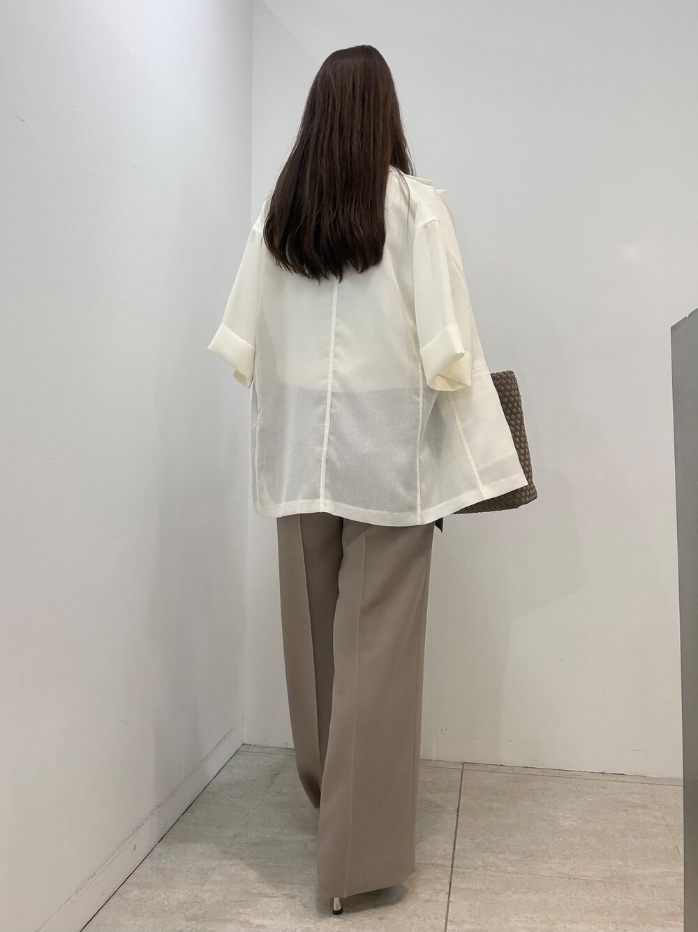 ホワイト系のニット/セーター、ベージュ系のその他パンツ、ホワイト系のテーラードジャケットを着用したレディースの夏コーディネートの5枚目の写真