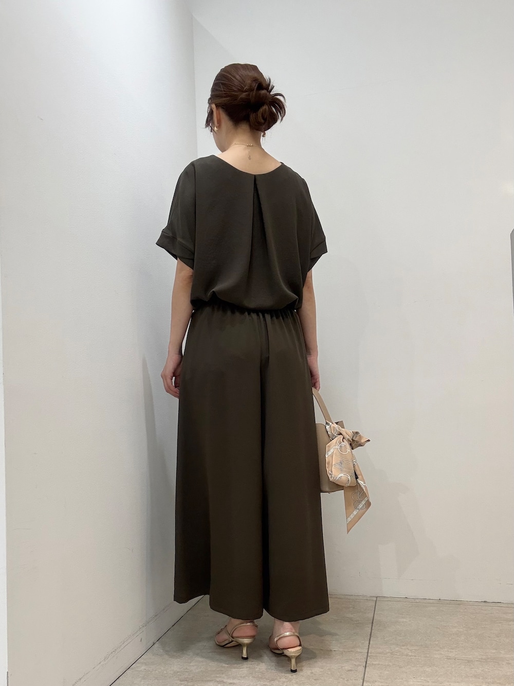 ブラウン系のその他パンツ、ブラウン系のシャツ/ブラウス、ベージュ系のハンドバッグを着用したレディースの春コーディネートの3枚目の写真