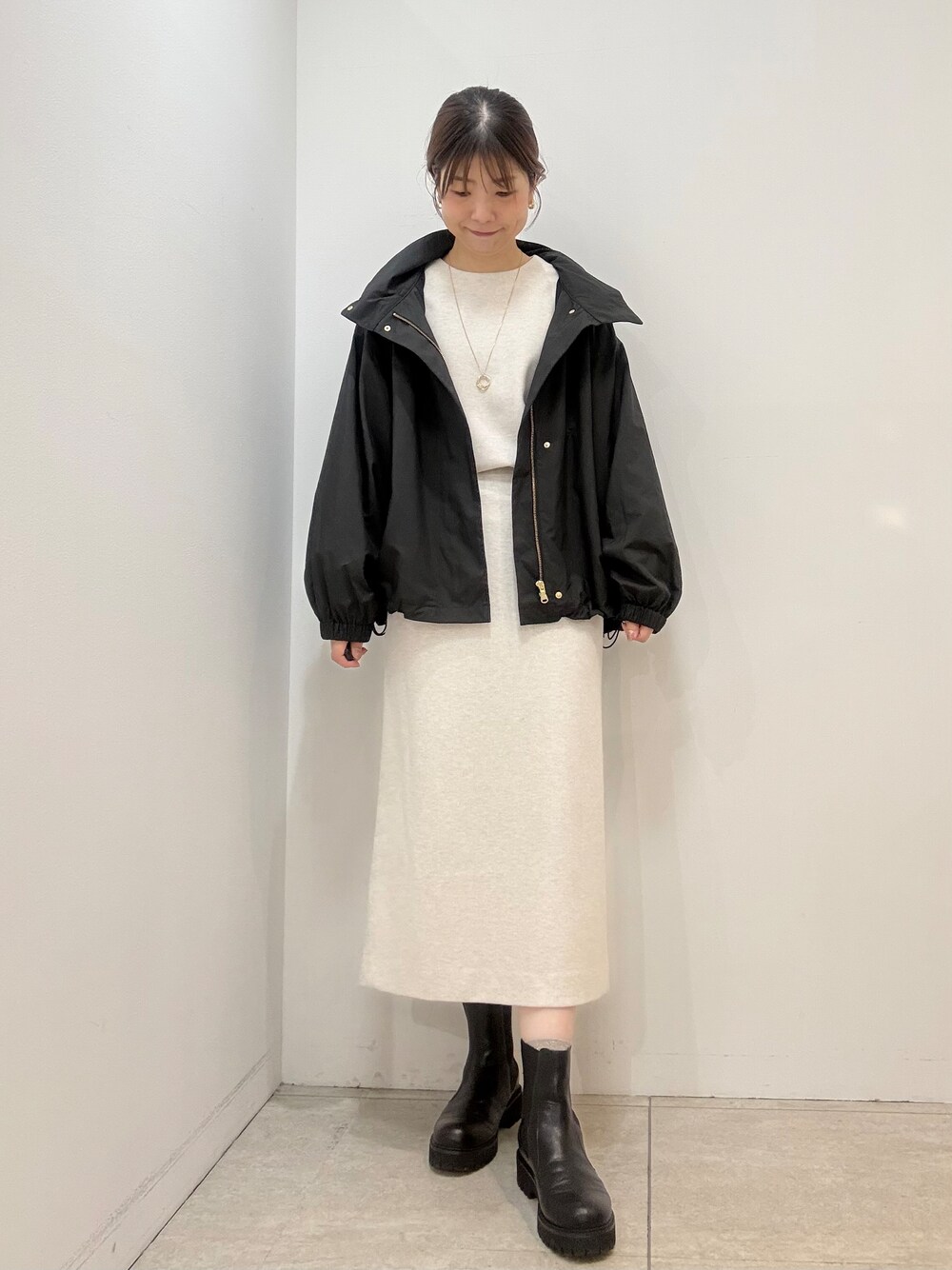 ホワイト系のTシャツ/カットソー、ホワイト系のスカート、ブラック系のブルゾンを着用したレディースの秋コーディネートの3枚目の写真