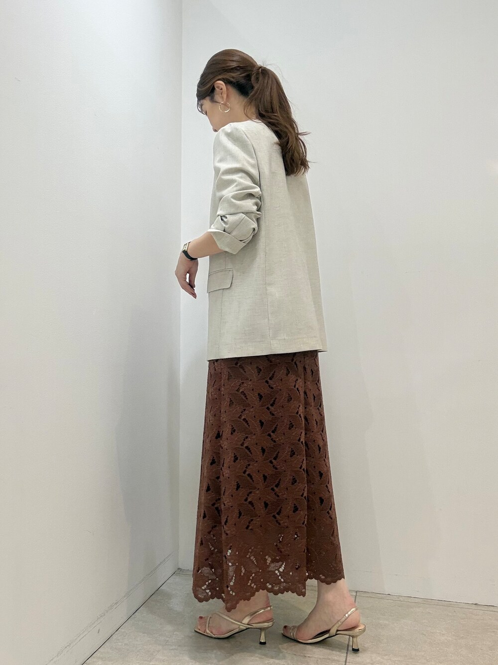 ベージュ系のノーカラージャケット、ベージュ系のアンサンブル、ブラウン系のスカートを着用したレディースの夏コーディネートの2枚目の写真