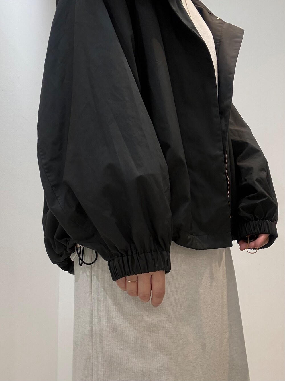 ホワイト系のTシャツ/カットソー、ホワイト系のスカート、ブラック系のブルゾンを着用したレディースの秋コーディネートの8枚目の写真
