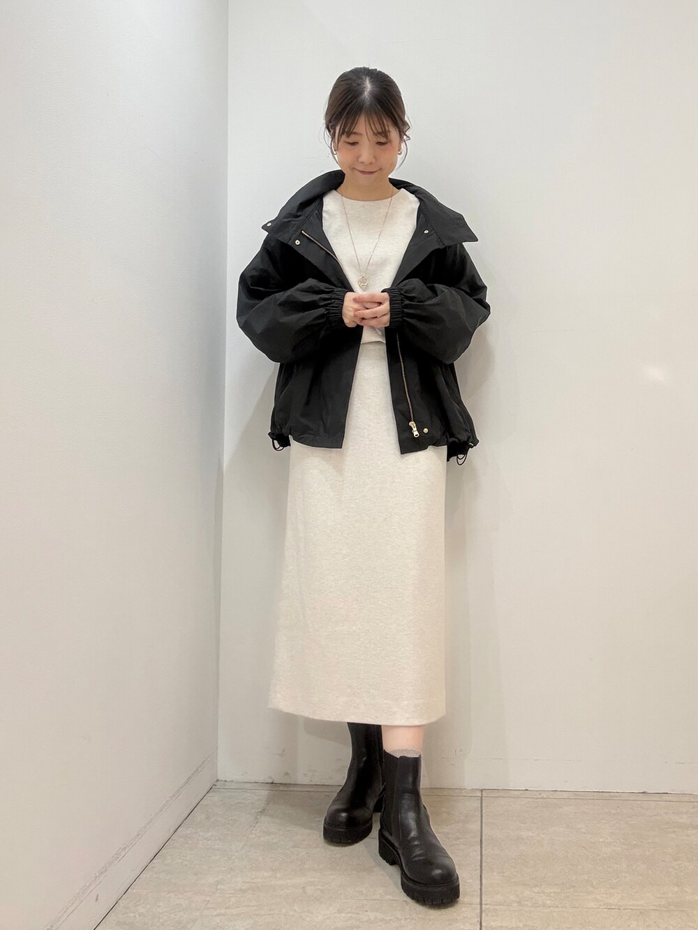 ホワイト系のTシャツ/カットソー、ホワイト系のスカート、ブラック系のブルゾンを着用したレディースの秋コーディネートの2枚目の写真