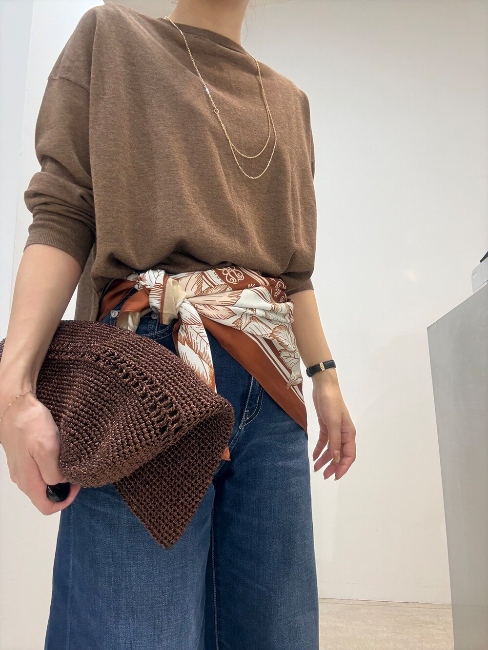 ブラウン系のカーディガン/ボレロ、ブラック系のタンクトップ、ブルー系のデニムパンツを着用したレディースの夏コーディネートの4枚目の写真