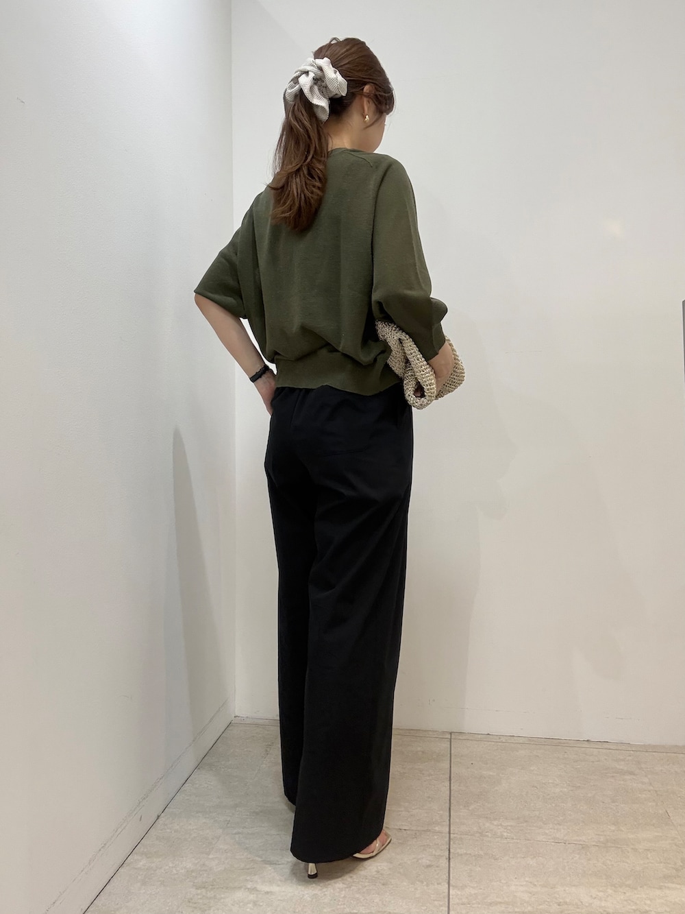 シルバー系のトートバッグ、グリーン系のカーディガン/ボレロ、ブラック系のその他パンツを着用したレディースの春コーディネートの3枚目の写真