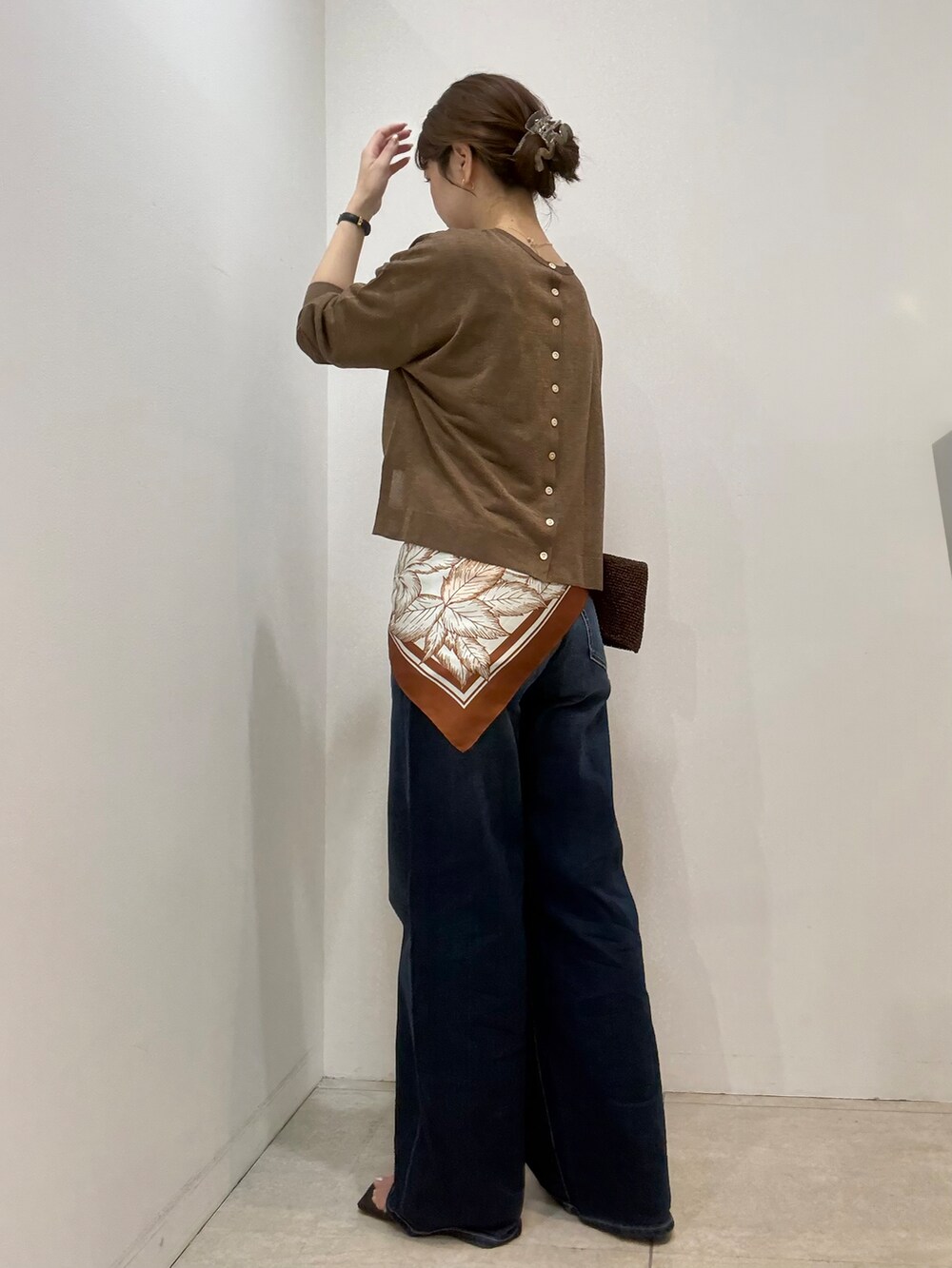 ブラウン系のカーディガン/ボレロ、ブラック系のタンクトップ、ブルー系のデニムパンツを着用したレディースの夏コーディネートの3枚目の写真
