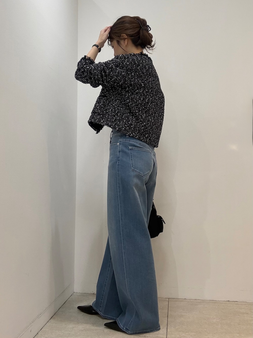 グレー系のTシャツ/カットソー、ブルー系のデニムパンツを着用したレディースの秋コーディネートの4枚目の写真