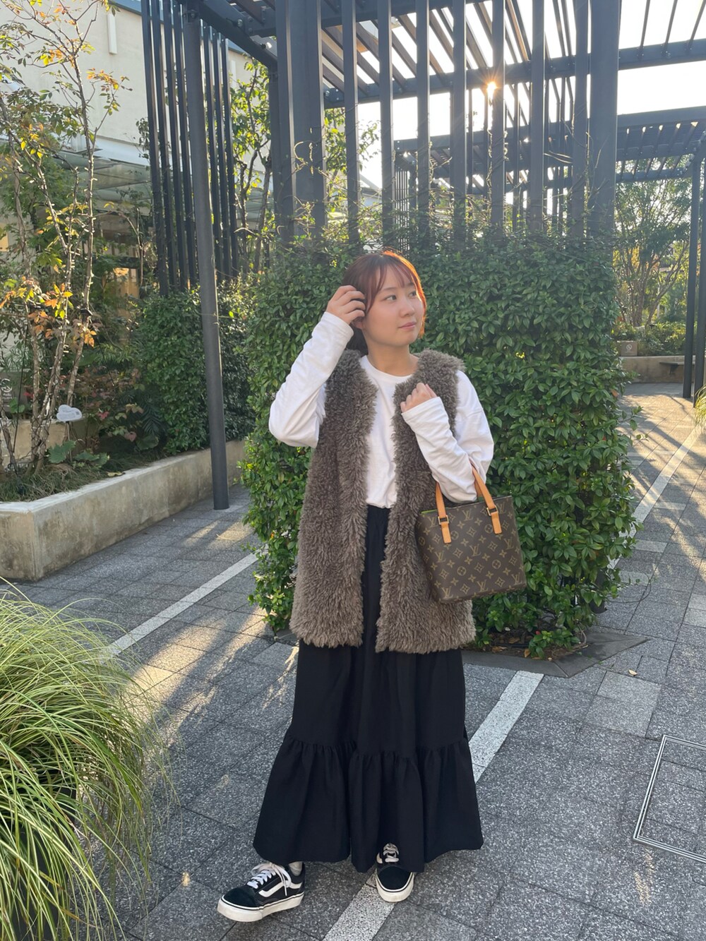 ホワイト系のTシャツ/カットソー、グレー系のベスト、ブラック系のスカートを着用したレディースの秋コーディネートの2枚目の写真