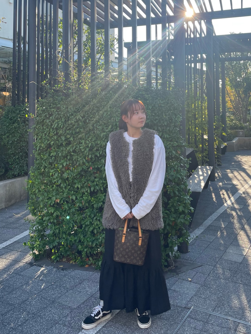 ホワイト系のTシャツ/カットソー、グレー系のベスト、ブラック系のスカートを着用したレディースの秋コーディネートの3枚目の写真