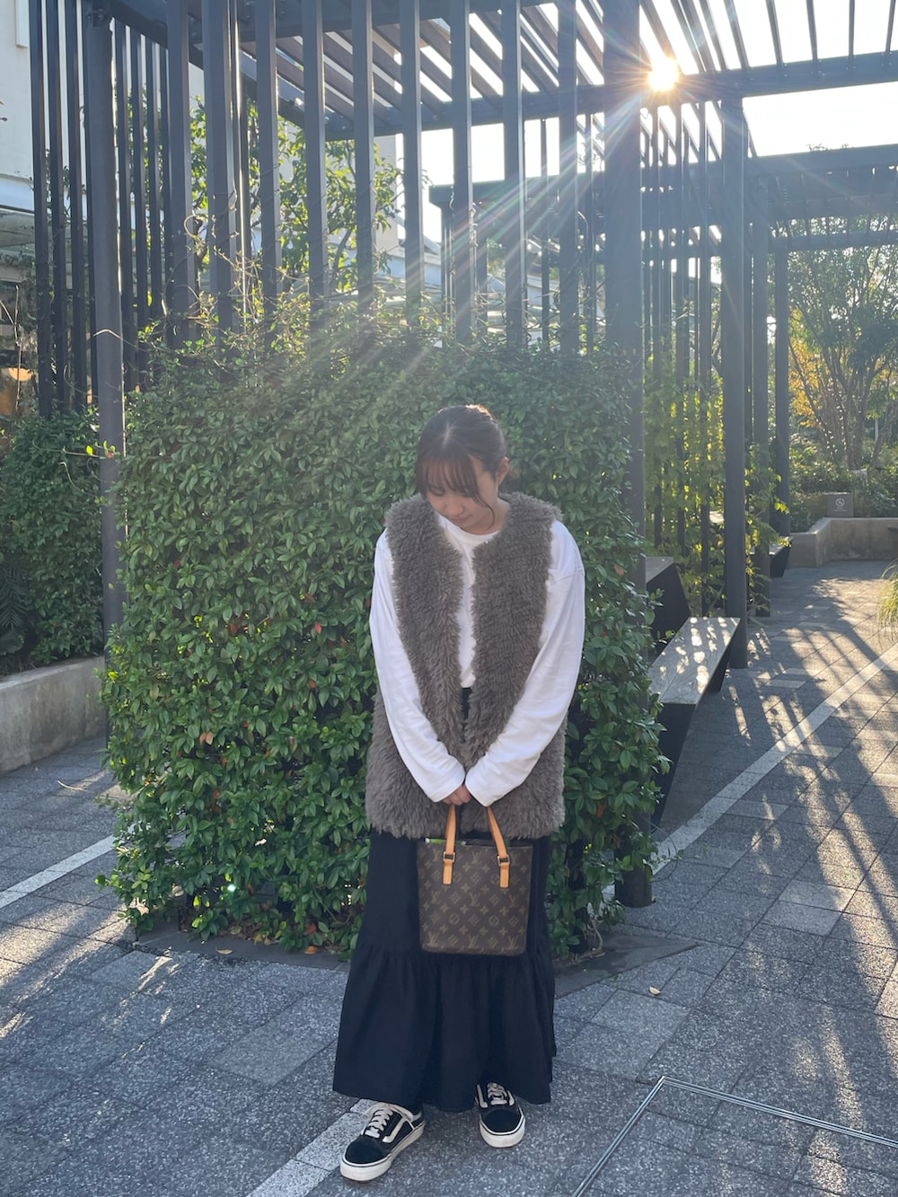 ホワイト系のTシャツ/カットソー、グレー系のベスト、ブラック系のスカートを着用したレディースの秋コーディネートの4枚目の写真